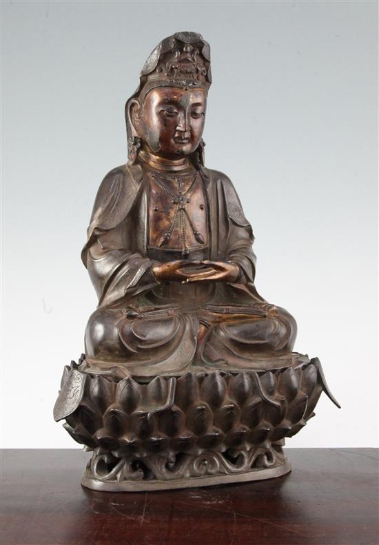 A Chinese bronze seated figure of Guanyin, with separate stand, 35.5cm.